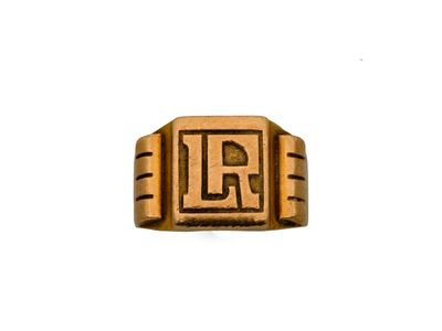 un gros plan d'une bague en or sur laquelle figure la lettre « l »
