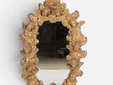 a mirror that has a gold frame with flowers on it
