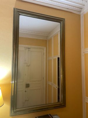 un miroir dans un coin d'une pièce où une lampe est allumée