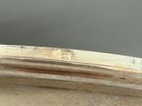 a silver plate with a handle on it on a table