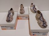 Quatre paires de chaussures pour femmes sont exposées dans une vitrine.