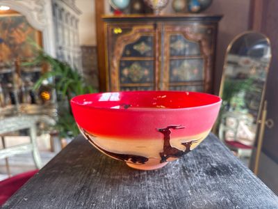 a red bowl sitting on top of a wooden table