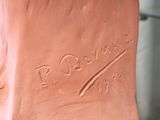 a clay sculpture of a person ' s foot with a hand on it