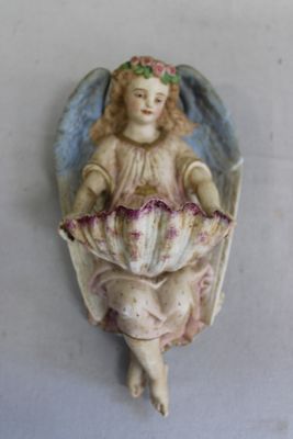 une figurine représentant un ange tenant une fleur à la main