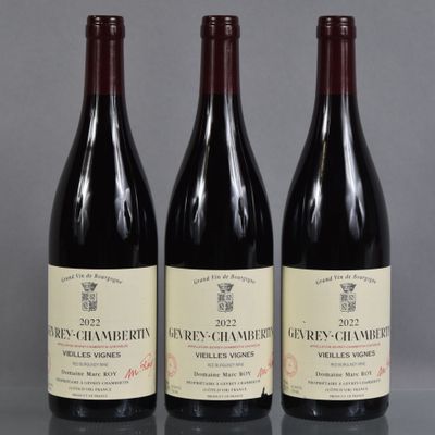 trois bouteilles de vin sont alignées sur une table