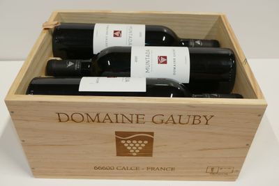 trois bouteilles de vin dans un coffret en bois sur une table