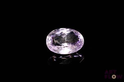 un gros plan d'une pierre précieuse violette sur une surface noire
