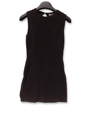 une robe noire suspendue à un cintre sur un mur blanc