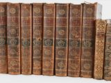 many old books that are lined up on a shelf