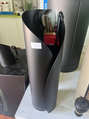 un vase noir contenant un stylo, posé sur une table