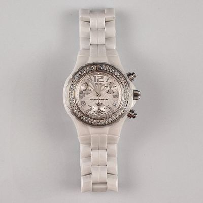 un gros plan d'une montre sur une surface blanche avec un fond blanc