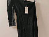 La robe noire est suspendue à un cintre accroché au mur.