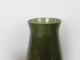 a green vase sitting on a table next to other vases