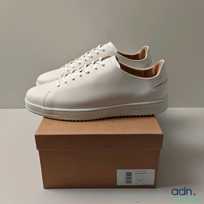 a pair of white sneakers sitting on top of a box