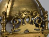 a gold clock with a cat on top of it