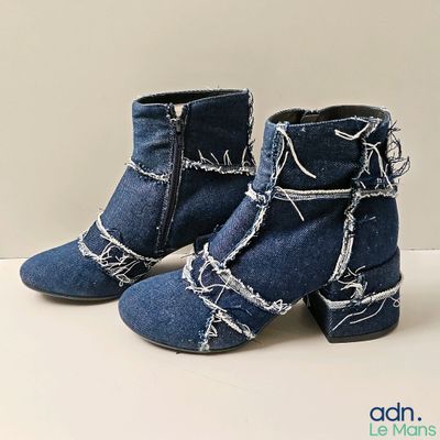 une paire de bottines en jean bleu ornées de fil barbelé