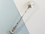 a silver spoon with a handle on a blue and white background