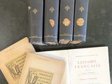 trois livres sont posés sur une table, à côté d'une pile de livres