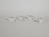 trois oiseaux en verre transparent posés sur une surface blanche