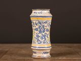 a blue and yellow vase sitting on a wooden table