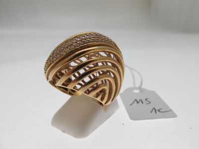gros plan d'une bague en or avec des diamants sur une surface blanche