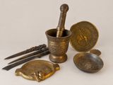 an assortment of brass objects including a mortar, spoon, and other items