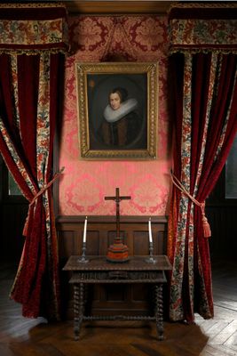 un tableau accroché au mur au-dessus d'une table sur laquelle se trouve une croix