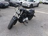 une moto garée sur un parking, à côté de nombreuses voitures