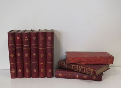 Plusieurs livres rouges sont empilés les uns sur les autres sur une table