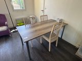 a table and chairs in a room with wood floors