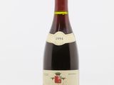 une bouteille de vin rouge posée sur une table blanche