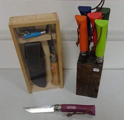 un couteau dans une boîte en bois, à côté d'une paire de ciseaux