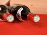 three bottles of wine sitting on a red cloth