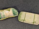 deux assiettes ornées de motifs verts, posées sur une table