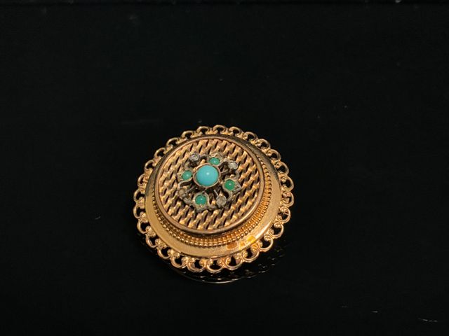 Broche ronde en or à décor de perles turquoise. En règle. Poids b...
