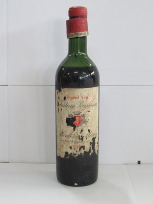 une vieille bouteille de vin posée sur un plan de travail blanc