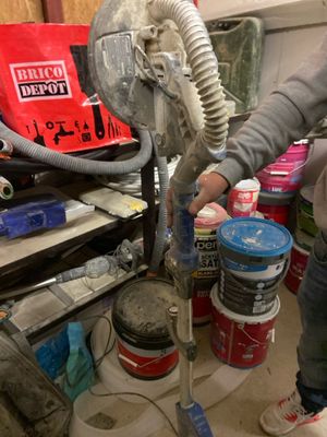 a woman that is working on a fan in the garage
