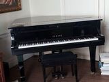 a piano in the corner of a room with a rug on the floor