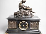 une statue de femme assise au sommet d'une horloge