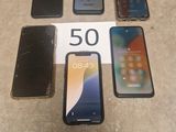 Quatre iPhones sont posés les uns à côté des autres sur une table.