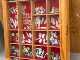 une vitrine en bois contenant de nombreuses petites figurines