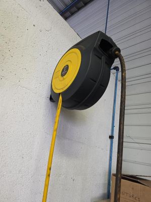 un tuyau fixé au mur, muni d'une poignée jaune