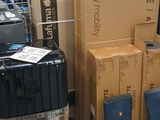 many boxes and suitcases on a shelf in a store
