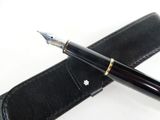 a pen that is laying on top of a leather case