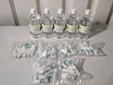several bottles of water are sitting on a table next to a bunch of pills
