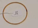une photo d'un bracelet en or auquel est attachée une étiquette