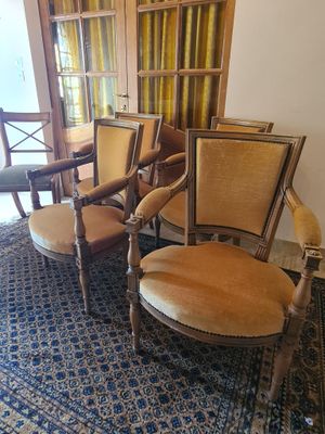 plusieurs chaises et une table dans une pièce recouverte d'une moquette bleue