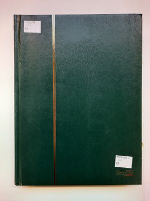 un livre vert posé sur une table à côté d'un mur blanc