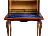 an antique writing desk with a blue top and a wooden shelf
