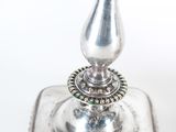 pair of silver candlesticks on a silver plate with a beaded edge